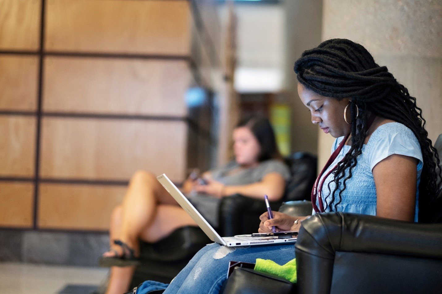 Woman studies with a laptop inside of Mitchell Memorial Library at Mississippi State University
