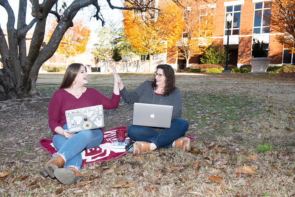 Women sitting on a blanket outside