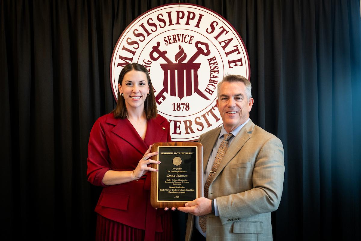 MSU Associate Vice President for Academic Affairs Jim Dunne, left, presents the Donald Zacharias Early Career Undergraduate Teaching Excellence Award to Jenna Johnson.
