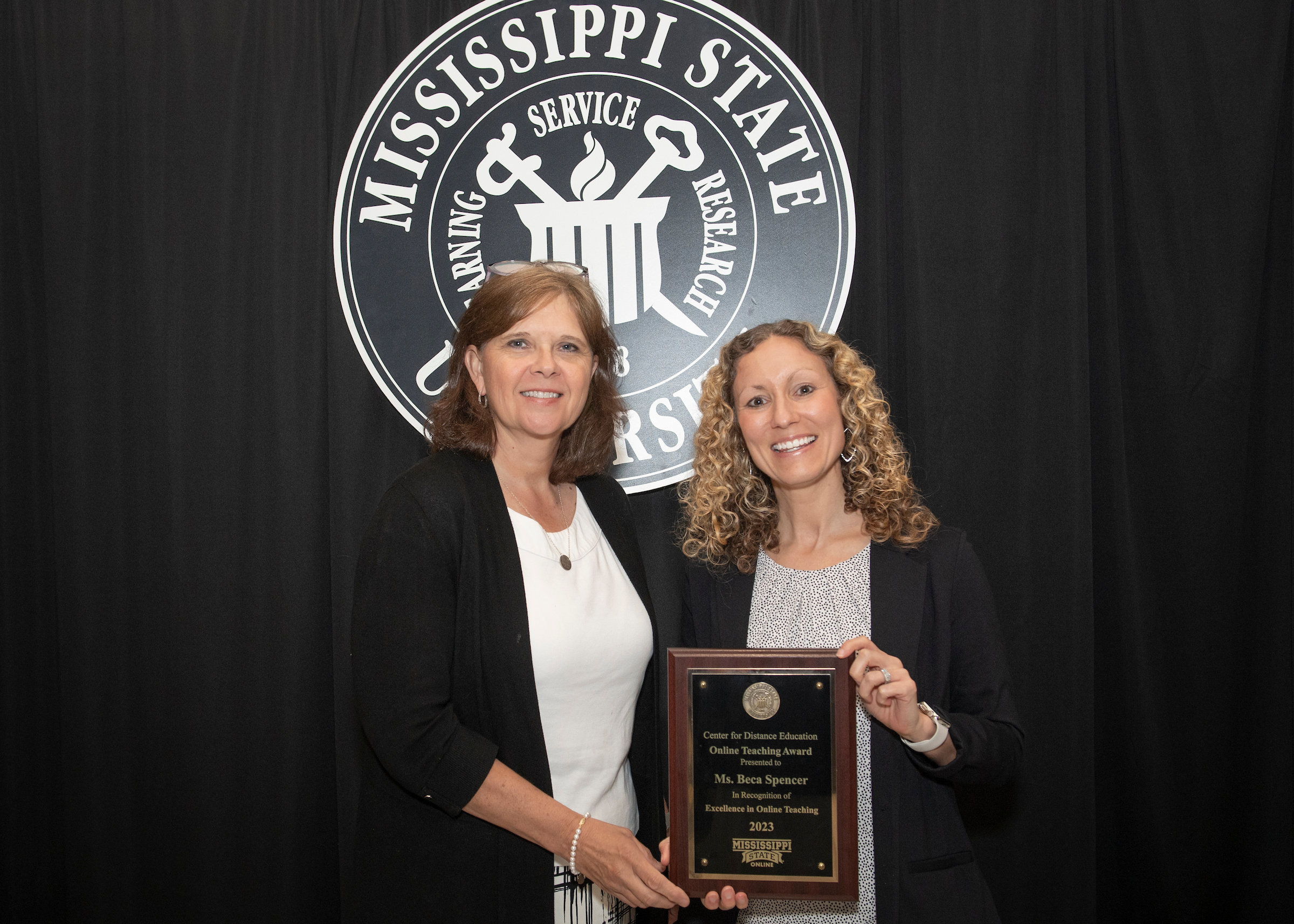 Center for Distance Education Executive Director Susan Seal presents Rebecca "Beca" Spencer with the CDE Online Teaching Excellence Award. (Photo by Megan Bean)