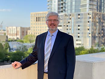 Nathan Gatlin standing on a rooftop in a urban environment