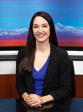 Katie Zuniga sitting at a desk smiling