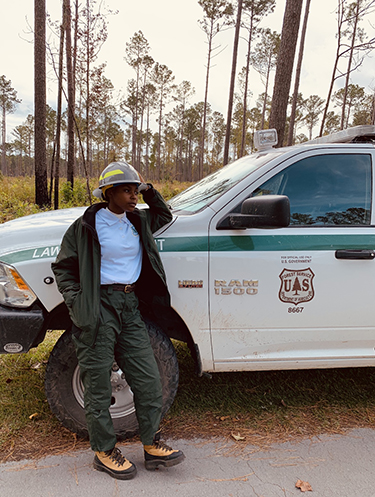 Tyler Willingham standing against a Department of Agriculture Forest Service truck.